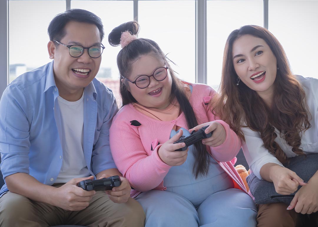 Young Asian girl playing video games with mother and father
