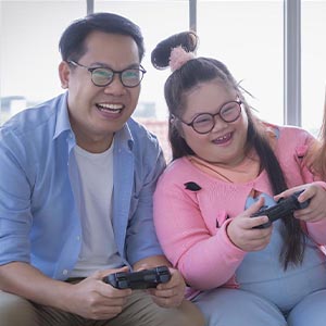 Young Asian girl playing video games with father
